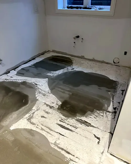 Patching compound across a concrete floor before levelling