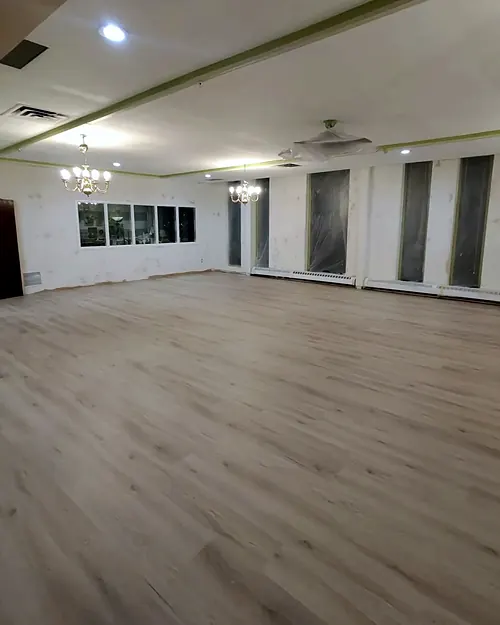 Grey luxury vinyl plank across a large hall with pot lights