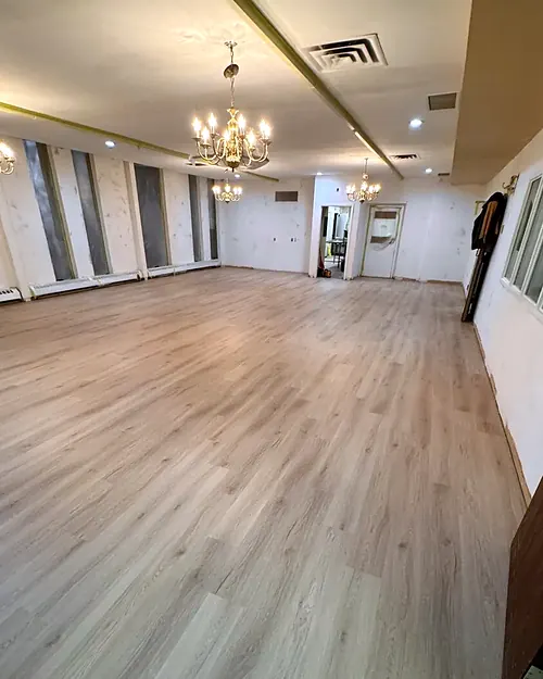 Light luxury vinyl plank across a large open hall with chandeliers