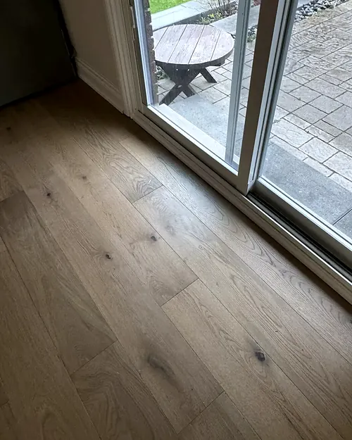 Wide oak plank floor running to sliding patio doors