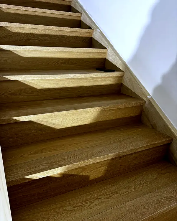Straight staircase with new light wood-look treads and matching risers